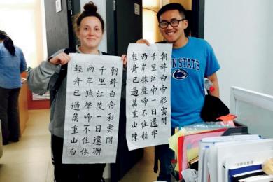 Two students holding up their Chinese character writings