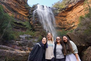 students visiting the Blue Mountains, posing for a photo in front of a waterfall