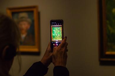 A women takes a picture of a Van Gogh painting in the Rijksmuseum in Amsterdam.