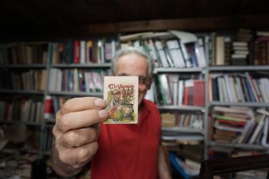 A book collector holds a small page in Rome, Italy.