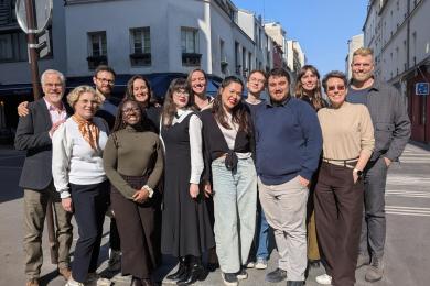 Group of people smiling on a street with a beautiful blue sky in the background