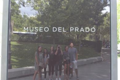 Group of students taking their photo in reflection of window at Museo del Prado