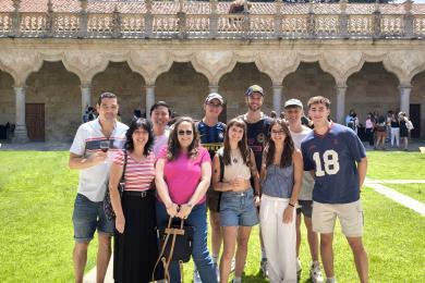 A Group of Students and their teacher in the IES Abroad commons on a sunny day.