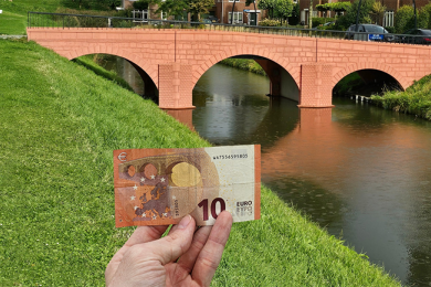 A student holds up local currency
