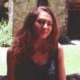 Katya Schwenk smiling outside in front of a brick building.