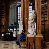 A boy sitting on a bench looking at the beautiful library in Rabat