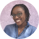 Phoenix Pittman smiling in front of pink background.