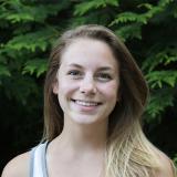 Samantha Hubbard headshot, smiling and standing in front of a tree