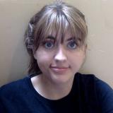 Claire headshot, slight smile in front of neutral backdrop