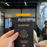 A student holds their passport as they wait in line to board their plane.