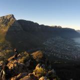 student hiking on mountain next to water