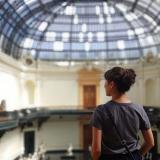 A picture of a girl looking at the building she is in