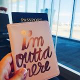Student holds a passport in a case that reads "I'm outta here"