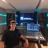 student smiling with hat on in front of audio visual equipment