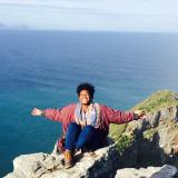 Student stretching arms out on a mountain