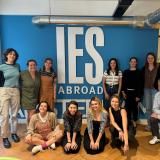 group of staff sitting and standing in front of blue wall that reads "IES Abroad Amsterdam"