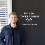 student standing in front of sign that reads "bondi advertising think outside the flags"