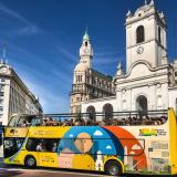 A tour bus in front of buildings in Buenos Aires