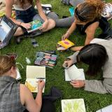 Students drawing in grass