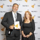 A man holding an award stands beside a woman