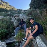 Two guys sitting on rocks in front of a blue sky in Cape Town.
