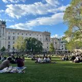 Students sit in the park on a sunny day in Vienna, Austria.
