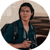 Man wearing denim shirt with a camera in his hand