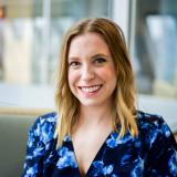 Abby Baric headshot, smiling in sun lit room
