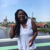 a student laughing in front of Amsterdam's windmills