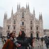 two students laugh while having their photo taken in front of Duomo di Milano