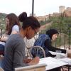 Three students in a painting class on the Granada Center patio