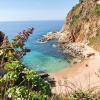 a secluded beach surrounded by natural cliffs and clear, blue waters