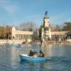 people paddling in blue boats in in Retiro Park Lake in Madrid