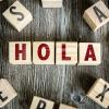Four different blocks each with different letters on them spelling out the word 'HOLA'