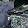 Two packed suitcases, a large one on the left, and a smaller one on the right with a pair of tap shoes sitting on top.