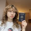 A young woman holds her passport