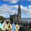 A line of colorful houses with an impressive Gothic cathedral behind them