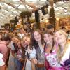 Seven study abroad students dressed in dirndls stand sideways, sandwiched together in the packed room, smiling for the picture in a tent at Oktoberfest.