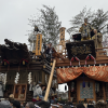Two of the floats from the Sawara Festival, with members sitting at the top of the float as well as in it. Pictured at the front are the people who help pull the float.