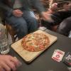 People playing Phase 10 and eating pizza