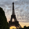 A silhouette of the Eiffel Tower in front of an orange sunset