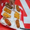 A sampling display of a saucy beef or cheese filling that is shaped into a breaded and fried ball. 