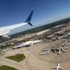 A view from the window of an airplane showing an aerial view of the Cleveland Hopkins airport on a sunny day with crystal clear skies.