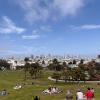 Picnic-goers enjoy the city skyline on a sunny day at San Francisco's Dolores Park.