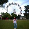 A girl in front of the Prater Ferris wheel