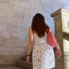 The author walks up a set of stone stairs, her back is to the camera.