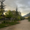 The sun is setting in Las Condes, Santiago with a mountain in the background and several trees shown