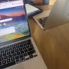 Two computers on a table sitting on a wooden table.