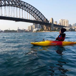 student kayaking in sydney harbour under the sydney bridge