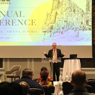 A man stands behind a podium in an auditorium